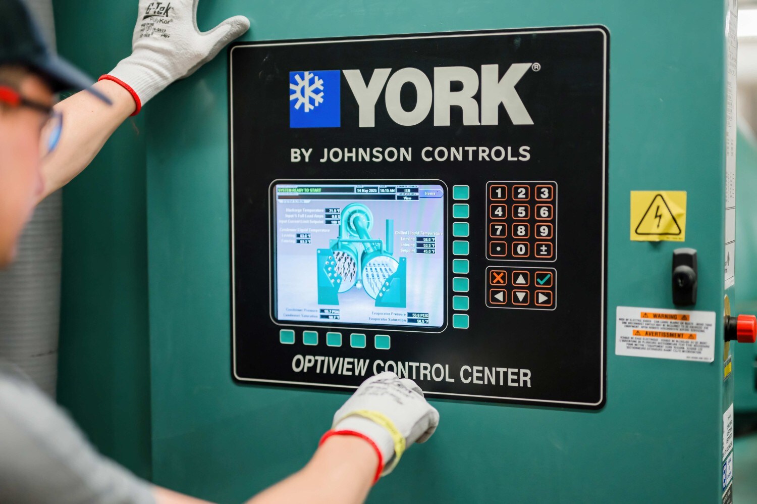 Operator using a YORK OptiView chiller control panel.